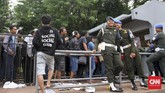 Petugas keamanan menjaga situasi penjualan tiket di loket Gelora Bung Karno, Jakarta. Salah satunya diamankan oleh para petugas Polisi Militer berikut. (CNN Indonesia/Denny Aprianto)