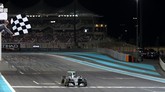 Setelah 10 musim membalap, Rosberg akhirnya mencapai mimpi menjadi juara dunia ketika melintasi garis finis GP Abu Dhabi. Di klasemen akhir F1 2016, Rosberg unggul lima poin dari Hamilton. (AFP PHOTO / MARWAN NAAMANI)