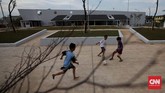 Tiga bocah bermain bola di RPTRA Kalijodo. Meski masih ada pengerjaan, pengunjung tetap diperbolehkan menghabiskan waktu di area yang telah dibuka, seperti lapangan bola di bagian depan. (CNN Indonesia/Safir Makki)