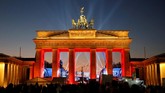 Sedangkan di Berlin, warga Jerman berkumpul untuk merayakan Tahun Barunya di Brandenburg Gate. Brandenburg Gate dihiasi dengan lampu-lampu indah dan berwarna-warni. (REUTERS/Fabrizio Bensch).