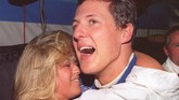Schumacher mendapatkan selamat dari kekasihnya, Corinna, setelah merebut gelar juara dunia kedua bersama Benetton pada 1994. Di musim itu Ayrton Senna tewas di Imola dan Schumacher mengambil alih kejayaan Senna. (AFP PHOTO / TORSTEN BLACKWOOD)
