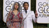 Para selebriti pria di Golden Globes 2017 biasanya memakai setelan jas hitam. Namun Pharrell Williams memilih menggunakan warna lain dalam setelan jasnya. Dia memilih jas panjang berwarna putih bermotif. Dia melengkapinya dengan rantai sisi dan dasi hitam.(REUTERS/Mike Blake)