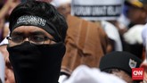 Sambil menunggu pemeriksaan Rizieq selesai, massa menggelar doa bersama di jalan raya. Massa juga mengelar salat zuhur berjamaah di badan jalan. (CNN Indonesia/Safir Makki)