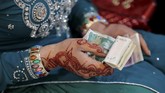 Sebagai imbalan karena sudah datang, para tamu diberikan 'uang ongkos' sesaat sebelum pulang. (REUTERS/Caren Firouz)