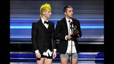 Tak lama, ada kejadian yang tak kalah menghebohkan. Twenty One Pilots yang memenangi Best Pop Duo/Group Performance, naik ke atas panggung sembari membuka celana mereka. Alhasil, mereka hanya mengenakan kemeja putih, jas, celana boxer, dan sepatu. (Kevin Winter/Getty Images for NARAS/AFP)