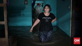 Seorang perempuan yang rumahnya terendam banjir di Jalan Bina Warga kawasan Rawajati, Jakarta Selatan, terendam banjir sejak Selasa (21/2) pagi. Ketinggian air di wilayah ini mencapai ketinggian hingga satu meter lebih. Warga membutuhkan penanganan segera. (CNN Indonesia/Andry Novelino)