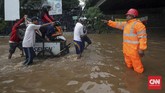 Sejumlah gerobak dikerahkan untuk membawa para pengendara motor untuk bisa menembus banjir yang tak dapat dilalui kendaraan di bawah ruas Jalan Tol Bintara, Bekasi, Selasa (21/2). Banyak warga yang merasa terbantu dengan adanya jasa gerobak-gerobak karena tak membuat pengendara memutar arah. (CNN Indonesia/Safir Makki)