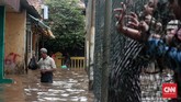 Seorang bapak tampak membawa barang yang dimasukan ke dalam plastik di wilayah Jalan Bina Warga, Rawajati, Jakarta Selatan, yang terkena banjir hingga satu meter lebih sejak Selasa (21/2) pagi. Kawasan ini kerap menjadi langganan banjir akibat meluapnya Kali Ciliwung saat hujan deras. (CNN Indonesia/Andry Novelino)
