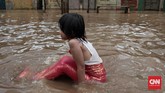 Di tengah kesulitan warga karena banjir, seorang anak perempuan yang mengenakan kostum ikan duyung, menikmati bermain air. Banjir di kawasan Jalan Bina Warga Rawajati, Jakarta Selatan, terjadi sejak Selasa (21/2) pagi. Ketinggian air di beberapa titik mencapai satu meter lebih. (CNN Indonesia/Andry Novelino)
