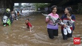 Selain beberapa pengendara sepeda motor yang nekat menembus banjir tanpa gerobak, sejumlah warga juga memaksakan diri menerjang banjir di bawah ruas Jalan Tol Bintara, Bekasi, Selasa (21/2). Banjir di kawasan ini sangat mengganggu aktivitas warga yang hendak melintas. (CNN Indonesia/Safir Makki)