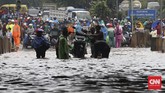Banjir yang mengepung sejumlah wilayah di Bekasi tak hanya menerjang kawasan perumahan tapi juga di jalanan. Pengendara sepeda motor terpaksa diangkut gerobak menembus banjir yang tak dapat dilalui kendaraan di bawah ruas Jalan Tol Bintara, Bekasi, Selasa (21/2). (CNN Indonesia/Safir Makki)