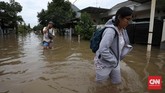 Selain ruas jalan, banjir juga menerjang kawasan permukiman penduduk seperti di Perumahan Pulo Permatasari, Bekasi Selatan, Selasa (21/2). Warga perumahan tersebut nekat menembus banjir agar bisa mencapai tujuan meskipun ketinggian air mencapai paha orang dewasa. (CNN Indonesia/Safir Makki)
