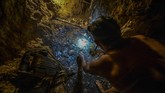 Mencari emas di dalam perut bumi, tidak sesulit mencari emas di permukaan. Dengan bantuan sorotan lampu senter di kepala, pekerja ini bisa melihat kilauan emas mentah. (AFP PHOTO/JUAN BARRETO)