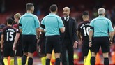 Manajer Manchester City Pep Guardiola berbicara dengan wasit Andre Marriner usai pertandingan di Stadion Emirates. Guardiola mengajukan sejumlah protes terhadap Marriner, terutama soal handball yang dilakukan bek Arsenal, Nacho Monreal. (Reuters / Eddie Keogh)
