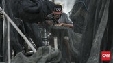Saat tak melaut, para nelayan Kamal Muara akan memperbaiki jala dengan cara menjahitnya. Sebagian nelayan memprotes reklamasi akan merampas ruang hidup mereka. CNN Indonesia/ Hesti Rika)