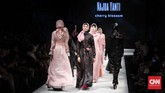 Najua Yanti menampilkan koleksi bertema 'Cherry Blossom' yang didominasi warna merah jambu dan hitam. Yang menonjol dari rancangannya adalah penempatan sejumlah motif di beberapa bagian busana, termasuk di bagian belakang hijab. (CNN Indonesia/Hesti Rika Pratiwi)
