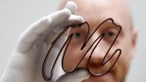 Gaetan Richard poses with the logo of the Miam Factory 3D printing chocolate company after being printed by a specialized 3D machine in Gembloux, Belgium, April 10, 2017. Picture taken April 10, 2017. REUTERS/Francois Lenoir