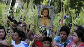 Seorang pria menjunjung gambar Yesus yang dikelilingi oleh hiasan dari pelepah daun kelapa sebagai bagian dari perayaan Pekan Suci di Manila, Filipina, 9 April 2017. (REUTERS/Romeo Ranoco)