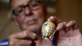Seniman Stjepan Biletic asal Kresevo, Bosnia Herzegovina menghias telur paskah dengan tapal kuda mini yang dibuatnya, 13 April 2017. (REUTERS/Dado Ruvic)