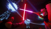 Di Singapura, para penggemar berkumpul di bawah pohon lampu Marina Bay, membuat kebun raksasa itu makin meriah dengan kostum-kostum mereka dan lampu lightsaber. (REUTERS/Edgar Su)