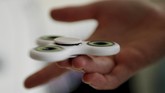 Fidget spinnner atau spinner merupakan permainan yang belakangan populer di kalangan anak-anak dan dewasa di Indonesia dan dunia. (REUTERS/Tom Jacobs)