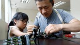 Chang mulai membuat lengan bionik untuk seorang gadis berusia 8 tahun, Angel Peng yang lumpuh akibat kecelakaan ketika ia berusia 9 bulan. (REUTERS/Tyrone Siu)