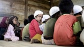 Suasana mengaji anak-anak Orang Rimba di sebuah rumah kayu. Anak-anak ini sekarang punya aktivitas lain selain menemani orang tua mereka berburu di hutan. (AFP PHOTO / GOH CHAI HIN)