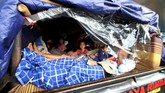 Pemudik menaiki mobil pikap yang tertutup terpal saat arus balik mudik Lebaran 2017 di Gerbang Tol Cikarang Utama, Jawa Barat, Jumat (30/6). Untuk menghindari kemacetan, Polri dan Jasa Marga membuka pintu pembayaran atau gate menjadi 31 pintu. (ANTARA FOTO/Rivan Awal Lingga/foc/17)