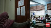 Orang tua mengamati absensi siswa di SDN Pasar Baru 03 Pagi. Anak yang baru masuk sekolah tak bisa hanya diantar sampai pintu gerbang sekolah dan ditinggalkan. Anak yang baru masuk sekolah biasanya diantar dan ditunggu sampai masuk kelas. (CNN Indonesia/ Hesti Rika)