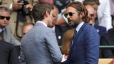 Aktor Eddie Redmayne (kiri) dan Bradley Cooper terlihat berbincang dengan serius sebelum pertandingan final. (REUTERS/Andrew Couldridge)