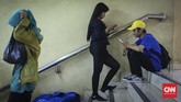 Pengunjung duduk di anak tangga penghubung Terminal dan Mal Blok M. Meskipun mal ini sudah berbenah dan mempercantik interior, kesepian menjadi ancaman pedagang. (CNNIndonesia/Safir Makki)