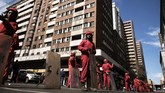 Sebuah blok di tengah kota Johannesburg, Afrika Selatan, ditutup sementara pekerja dari perusahaan keamanan Red Ants mengangkut barang-barang dari bangunan setinggi 12 lantai, Rabu (19/7). (AFP Photo/Marco Longari)