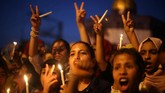 Tidak hanya pria dan anak-anak, wanita pun tidak ketinggalan menyuarakan protes mereka lewat nyala lilin. Mereka menginginkan wilayah Yerusalem kembali pada status quo dan warga Palestina bisa bebas beribadah tanpa harus melewati detektor logam ataupun pembatasan usia. (REUTERS/Ibraheem Abu Mustafa)