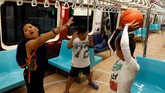 Demi totalitas, mereka juga mengenakan pakaian olahraganya sesuai dengan tema kereta olahraganya. (REUTERS/Tyrone Siu)