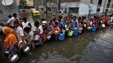 Bnajir membuat warga India banyak yang kekurangan makanan dan air bersih. Terlihat warga mengantri air bersih di tanki kota di Ahmedabad. (REUTERS/Amit Dave)