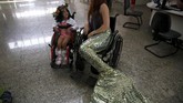Pernah satu kali, di rumah sakit anak Disabled Child Care Association (AACD) di Sao Paulo,, ia berpakaian ala putri duyung duduk di atas kursi roda di samping anak kecil yang juga berkursi roda untuk memberi semangat. (Foto/REUTERS/Pilar Olivares)