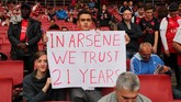 Seorang penggemar Arsenal menunjukkan poster jelang melawan Leicester City di Stadion Emirates, Jumat (11/8) malam waktu setempat. Mereka menunjukkan dukungan untuk manajer Arsenal Arsene Wenger. (REUTERS/Eddie Keogh)