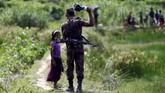 Ribuan warga minoritas Muslim Rohingya di Myanmar melarikan diri dari Rakhine ke arah Bangladesh dan disambut oleh petugas perbatasan. (Reuters/Mohammad Ponir Hossain)