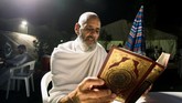Seorang jemaah di Jabal al-Rahmah membaca kitab suci Al-Quran. Hari Arafah adalah hari ke-9 dalam bulan Dzulhijjah dan merupakan hari ke-2 dalam ritual ibadah haji. (AFP PHOTO / BANDAR ALDANDANI)