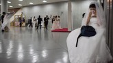 Mungkin mengejutkan, pernikahan-pernikahan ini memiliki tingkat keberhasilan yang jauh lebih tinggi darupada pernikahan cinta tradisional. Hanya 17 persen dari 2.075 pasangan yang dijodohkan oleh Moon Sun Myung pada 1982 dalam sebuah upacara di Madison Square Garden di New York. (AFP PHOTO/Ed JONES)