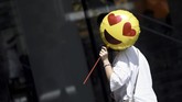 Seorang perempuan memegang balon ketika melewati toko di hari Valentine di China pada 28 Agustus 2017. Biasanya para perempuan menunjukkan kemampuan mereka serta berharap mendapatkan suami yang baik ketika festival Qixi atau festival Valentine di China tiba. (AFP PHOTO / WANG Zhao)
