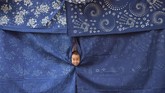 Seorang bocah bermain di pusat kerajinan kain di Shaoyang, Provinsi Hunan, China pada 18 Juli 2017. (REUTERS/Stringer)