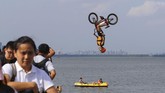 Seorang pria menunjukkan trik-trik menggunakan sepeda BMX. Ia melompat ke Danau Timur di Wuhan, Provinsi Hubei, China, pada 19 Agustus 2017. (REUTERS/Stringer)