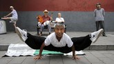 Seorang pria melakukan split ketika berlatih Kung Fu di Taman Beihai di Beijing China, 20 Agustus 2017. (REUTERS/Stringer)