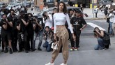 Para model di luar lokasi panggung NYFW kerap mendapat sorotan dari para fotografer. Pasalnya, jalanan dengan model berseliweran tak sering terjadi, kecuali saat pekan peragaan busana seperti NYFW. Seorang model berpose di luar Skylight Clarkson Square usai peragaan Concept Korea SS18 Collection. (REUTERS/Brenna Weeks)