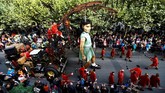 Kerumunan memadati jalanan kota Jenewa, Swiss, untuk menyaksikan sebuah boneka nenek raksasa setinggi 83 meter dan cucu perempuannya setinggi 6 meter. (REUTERS/Denis Balibouse)