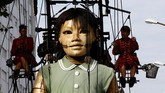 Masyarakat yang memadati pinggir jalan pun dengan sigap mengabadikan arakan boneka raksasa ini. (REUTERS/Denis Balibouse)