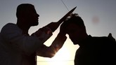 Muslim Syiah di Irak memangkas rambut di ubun kepala dengan menggunakan pisau sebagai simbol tradisi berkabung dalam peringatan Asyura. (AFP PHOTO / Haidar HAMDANI)
