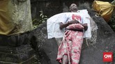 Jro Mangku di tempat persemayaman dengan posisi terlentang di petilasan seorang dewa. Jro memilih banyak berdoa untuk keselamatan masyarakat Bali di Pura ketimbang mengungsi. (CNN Indonesia/Andry Novelino)