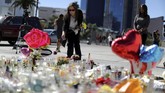 Beberapa hari setelah insiden penembakan yang menewaskan setidaknya 59 orang, warga masih saja berkumpul di sekitar lokasi kejadian. Mereka membawa bunga dan menyalakan lilin untuk mengenang para korban. (Reuters/Lucy Nicholson)